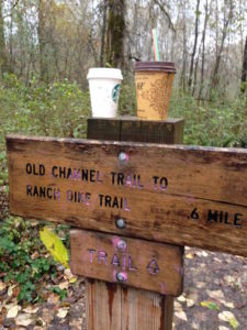 coffee cups sitting atop trail sign